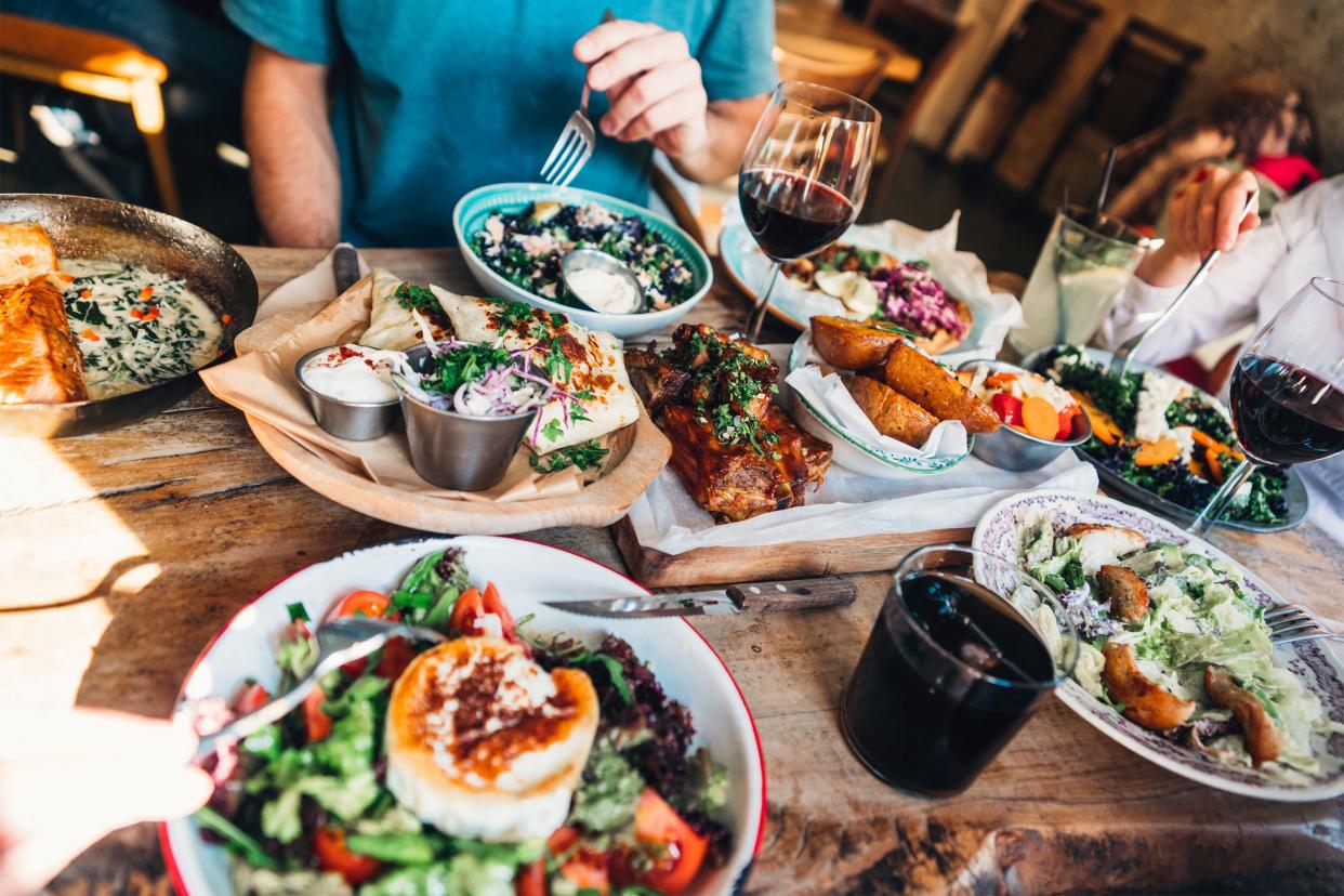 Group of friends having dinner at a restaurant with Mediterranean food