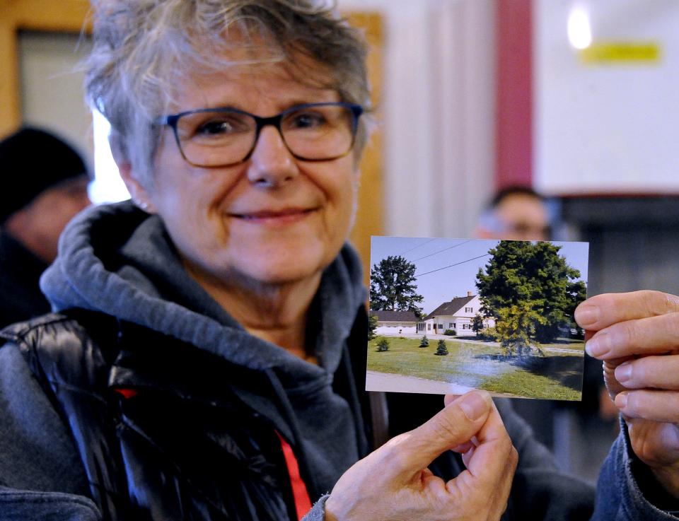Veronica Frontz holds an old photo showing the Christmas tree recently delivered to Cincinnatti. It is the small tree in the center of the photo. It was estimated to be approximately 40 years old when it was harvested. The tree was owned by Frontz Drilling.