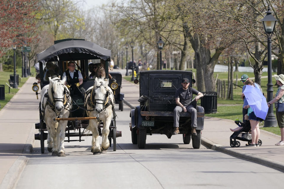 A horse drawn bus and Model T truck pass each other at The Henry Ford, Friday, April 14, 2023, in Dearborn, Mich. Named after Ford Motor Co. founder and American industrialist Henry Ford, The Henry Ford sits on 250 acres and features a museum and Greenfield Village where more than 80 historic structures are displayed and maintained. The Jackson House from Selma, Ala., will join the courthouse where Abraham Lincoln first practiced law, the laboratory where Thomas Edison perfected the light bulb and the home and workshop where Orville and Wilbur Wright invented their first airplane. (AP Photo/Carlos Osorio)