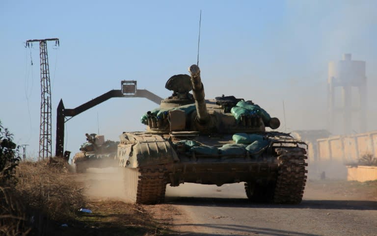 Syrian government forces' tanks drive through the village of Tal Jabin, north of the embattled city of Aleppo, as they advanced to break a siege of two government-held Shiite villages on February 3, 2016