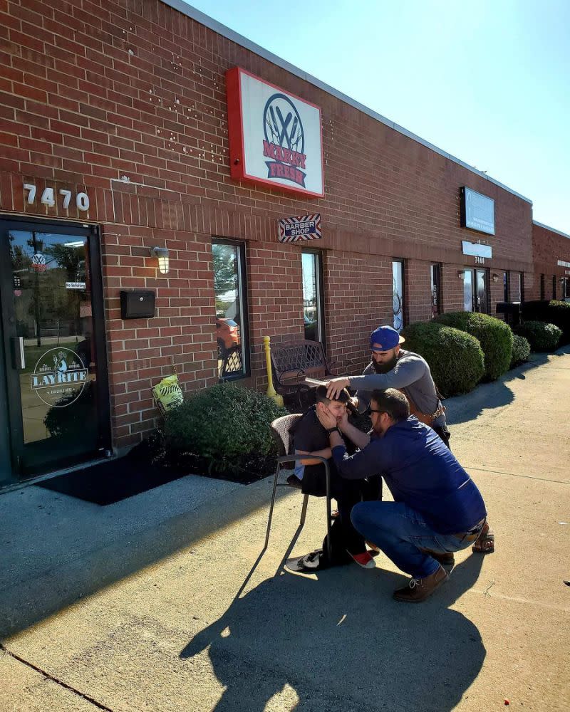 Marco Conti, copropriétaire de Marky Fresh Barbershop à Mentor, Ohio, coupe les cheveux de Brycen Juby dehors, le jeune garçon ayant peur d’entrer dans le salon. (Photo: Facebook)