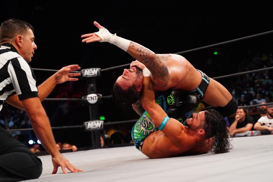 Matt Sydal, a Mizzou graduate and St. Louis native puts CM Punk in a submission hold during an episode of All Elite Wrestling Rampage on Oct. 15 in Miami. Also pictured is AEW referee Paul Turner.