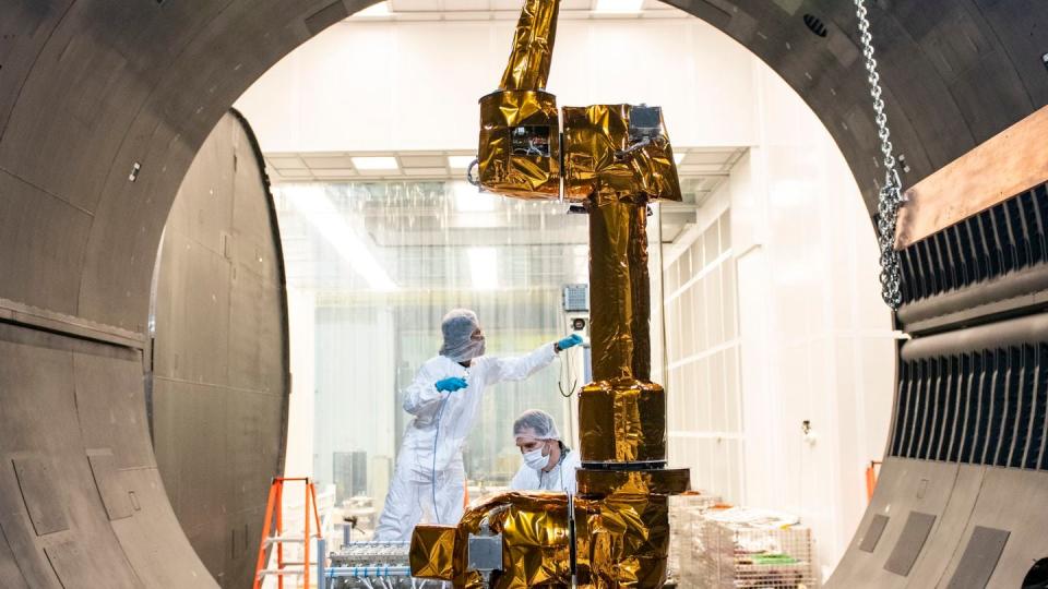 Members of the U.S. Naval Research Laboratory’s Robotic Servicing of Geosynchronous Satellites team prepare a robotic arm for testing in June 2022. (Sarah Peterson/U.S. Navy)
