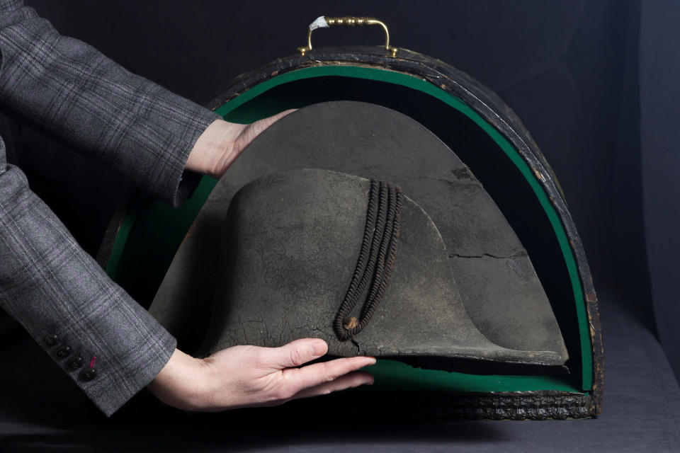 An employee displays a black felt two-cornered hat belonging to French Emperor Napoleon Bonaparte, recovered on the battlefield of Waterloo by the captain of Holland Dragons, before its auction at De Baecque and associates auction house in Lyon, France, April 17, 2018.   REUTERS/Emmanuel Foudrot