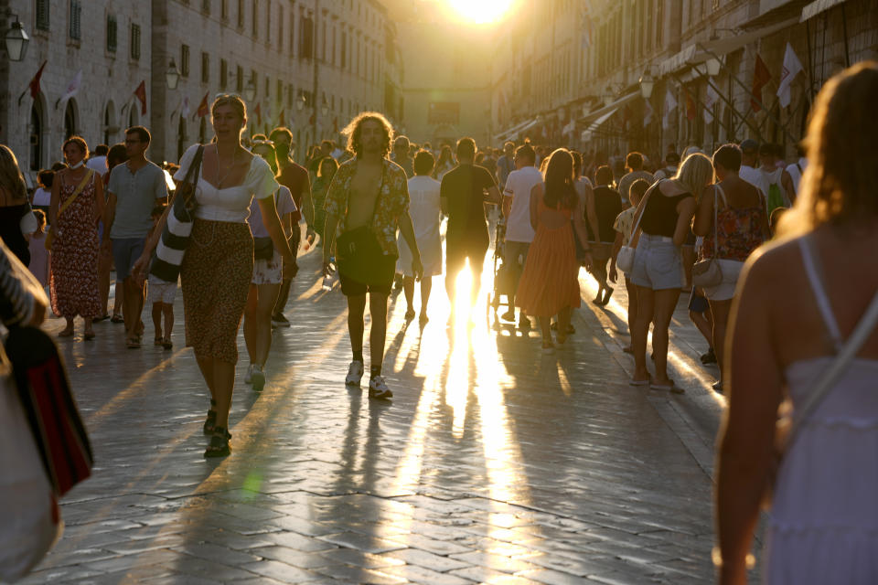 Holidaymakers walk through the old town of Dubrovnik, Croatia, Friday, Aug. 13, 2021. Summer tourism has exceeded even the most optimistic expectations in Croatia this year. Beaches along the country's Adriatic Sea coastline are swarming with people. Guided tours are fully booked, restaurants are packed and sailboats were chartered well in advance. (AP Photo/Darko Bandic)