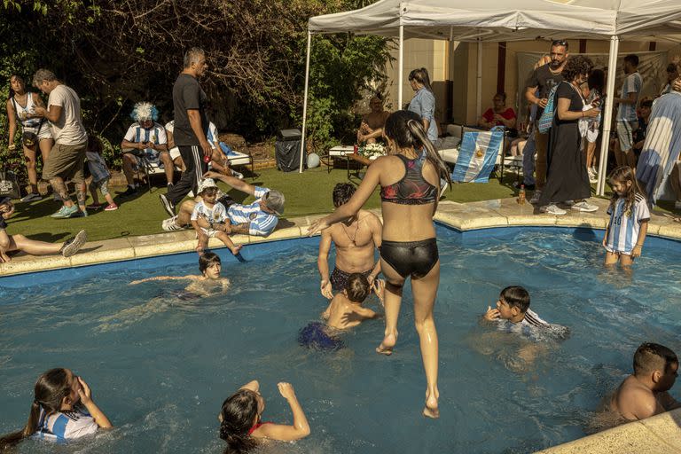 Argentine soccer fans celebrate during a soccer match watch party at Diego Maradona’s former home in Buenos Aires, Argentina, Dec. 13, 2022. The house is one of several Maradona owned in Buenos Aires. (Sarah Pabst/The New York Times)
