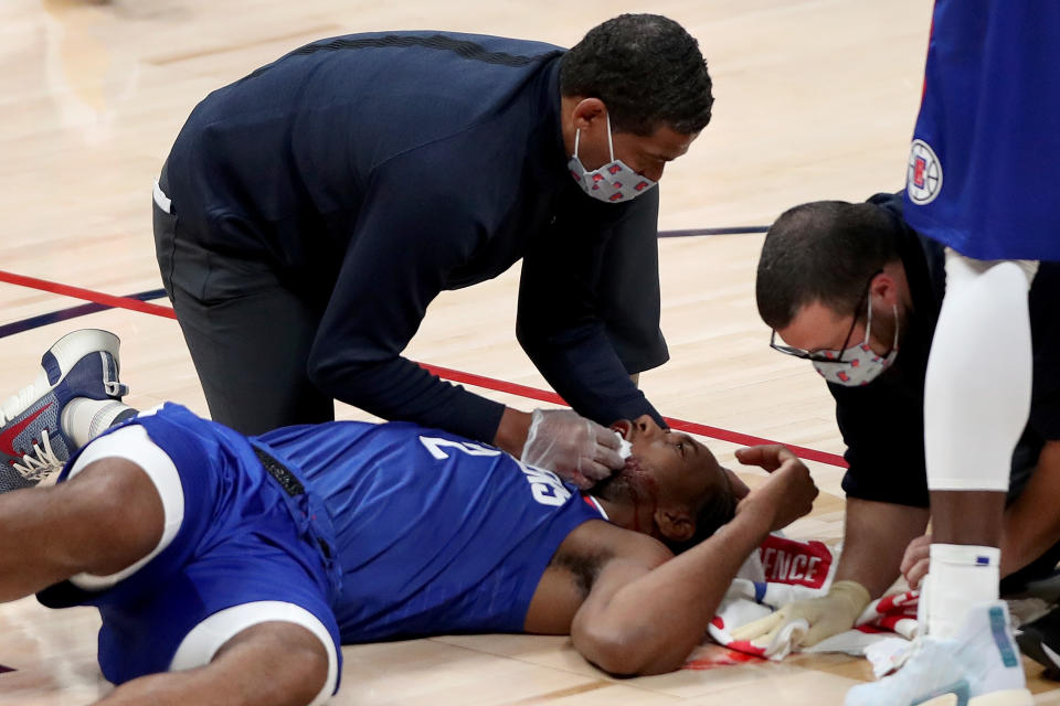 Kawhi Leonard #2 of the Los Angeles Clippers is attended to after being injured against the Denver Nuggets in the fourth quarter at Ball Arena.