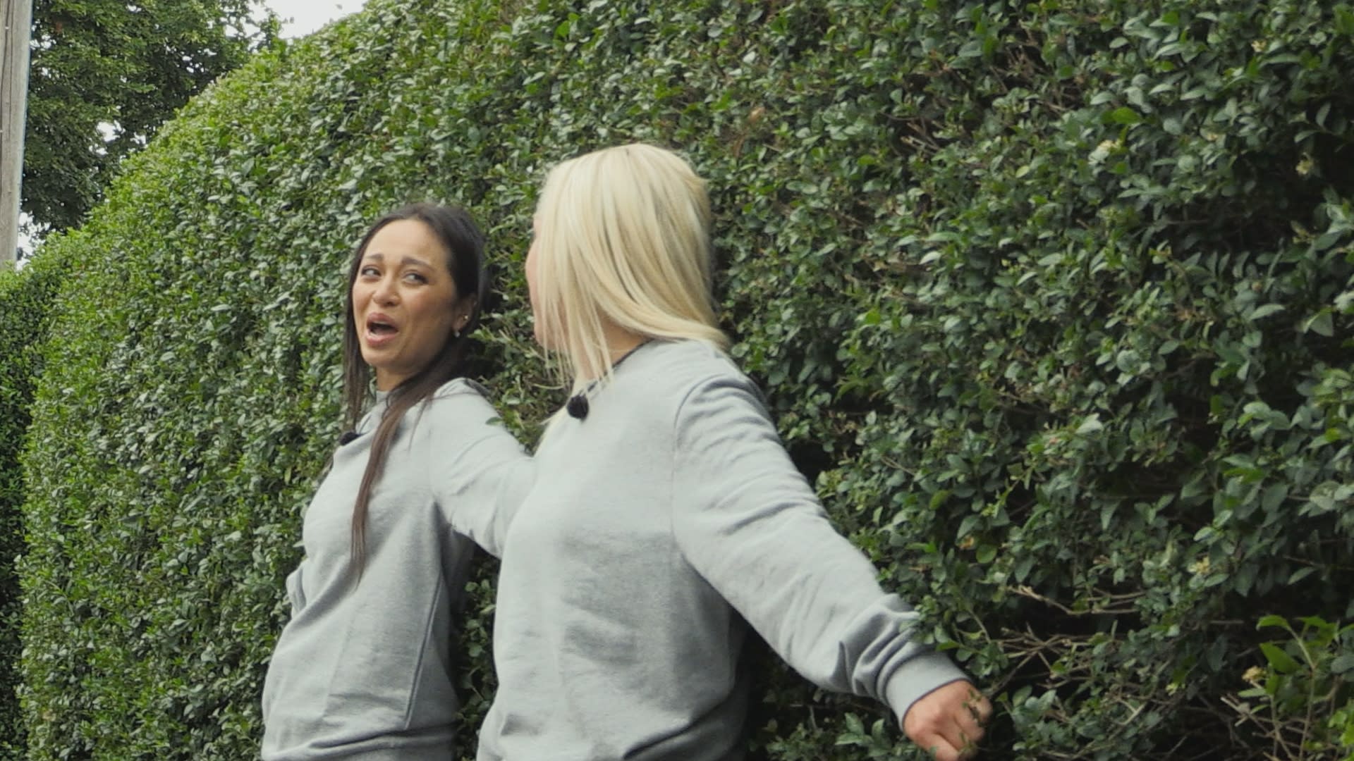 Katya Jones and Amiee Fuller hiding in a bush on Celebrity Hunted 2023