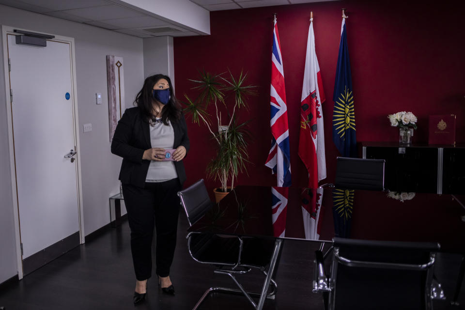 Gibraltar Health Minister Samantha Sacramento at her office prior to an interview with The Associated Press, in Gibraltar, Thursday, March 4, 2021. Gibraltar, a densely populated narrow peninsula at the mouth of the Mediterranean Sea, is emerging from a two-month lockdown with the help of a successful vaccination rollout. The British overseas territory is currently on track to complete by the end of March the vaccination of both its residents over age 16 and its vast imported workforce. But the recent easing of restrictions, in what authorities have christened “Operation Freedom,” leaves Gibraltar with the challenge of reopening to a globalized world with unequal access to coronavirus jabs.(AP Photo/Bernat Armangue)