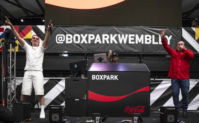 Aitch and Shaun Williamson perform Sweet Caroline on the Coca-Cola Zero Sugar stage at BOXPARK Wembley