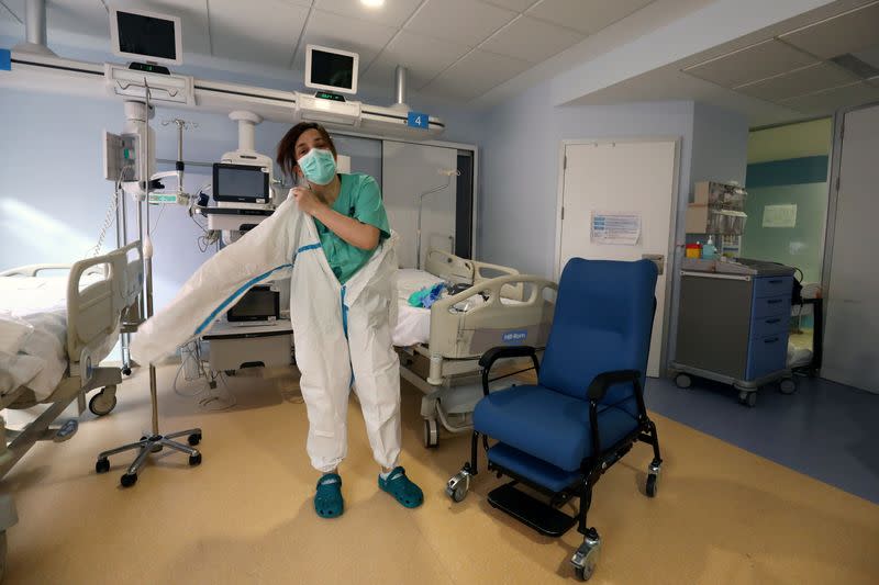 La enfermera Cristina Cadenas, de 53 años, se pone un equipo de protección personal (PPE) completo al comienzo de su turno en el hospital Príncipe de Asturias, en medio del brote de la enfermedad coronavirus (COVID-19), en Alcalá de Henares, España