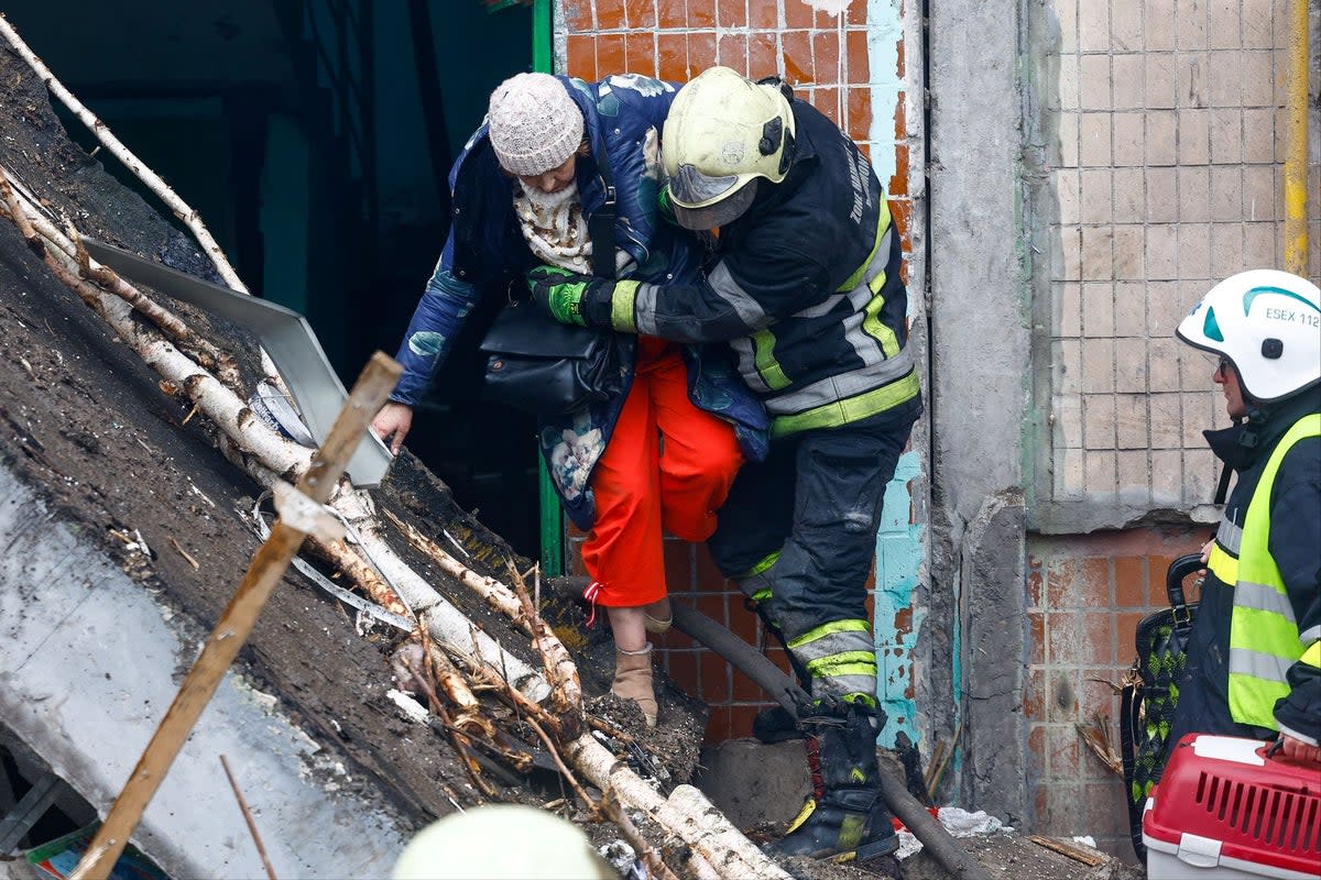 A woman is helped from a damaged building after a Russian missile attack (REUTERS)
