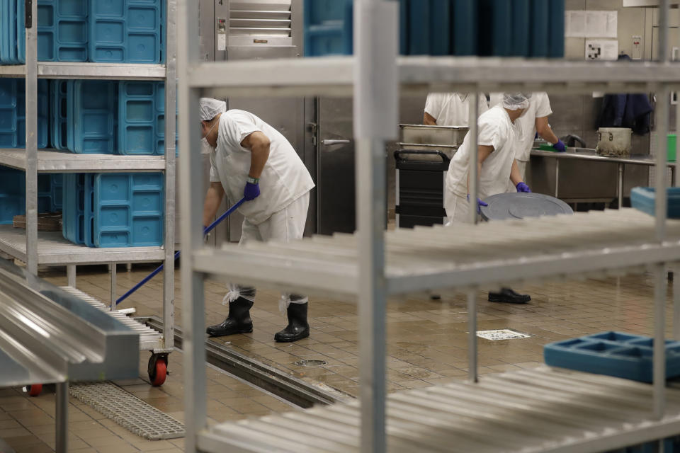 FILE - In this Sept. 10, 2019, file photo, workers are shown in the kitchen of the U.S. Immigration and Customs Enforcement detention facility in Tacoma, Wash., during a media tour. After years of litigation and pandemic-related delays, jury selection is underway in a trial to determine whether GEO Group must pay minimum wage to detainees at its immigration detention center in Washington state. (AP Photo/Ted S. Warren, File)