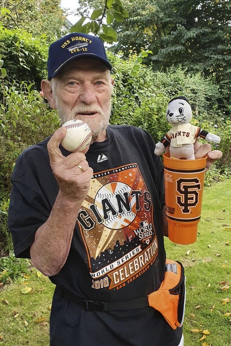 This Wednesday, Sept. 23, 2020, photo provided by Christiane Pohl-Rolfes shows her father, San Francisco Giants fan Manner Pohl, holding a baseball in Flensburg, Germany. (Christiane Pohl-Rolfes via AP)