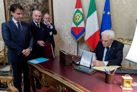 Italy's Prime Minister-designate Giuseppe Conte looks on as Italian President Sergio Mattarella signs documents at the Quirinal Palace in Rome, Italy, May 31, 2018. Italian Presidential Press Office/Handout via REUTERS ATTENTION EDITORS - THIS IMAGE HAS BEEN SUPPLIED BY A THIRD PARTY