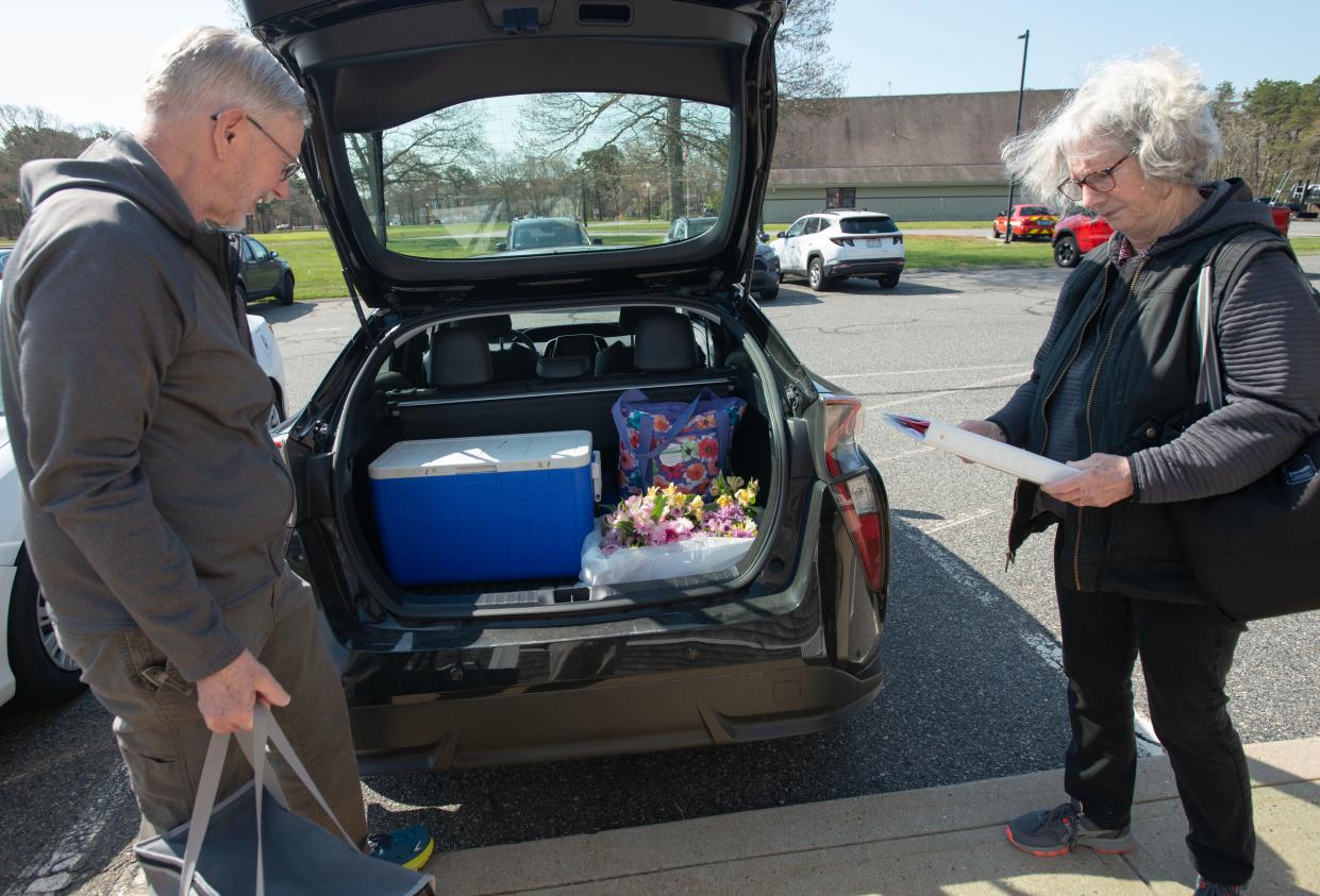 Sandee Loew, right, checks a log book as her husband, Jim, finishes loading their car Thursday at the Mashpee Senior Center for Meals on Wheels deliveries. The food delivery program is facing a severe shortage of drivers, according to Elder Services of Cape Cod and the Islands.