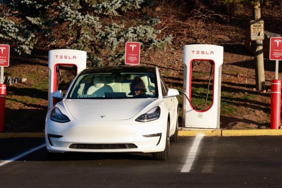 White Tesla Model 3 charging at Supercharger