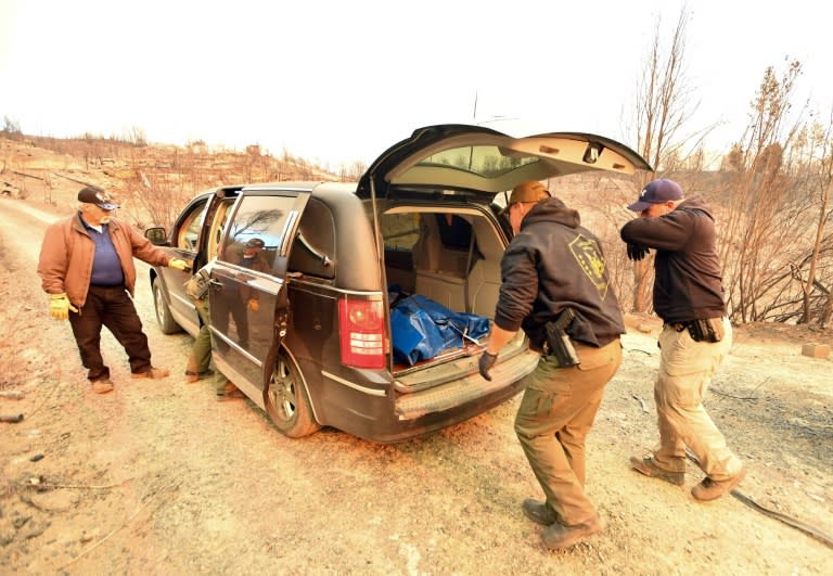 Sheriff deputies load the body of an unknown man who died in California's Camp Fire into a hearse