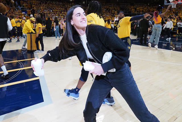 <p>Ron Hoskins/NBAE via Getty I</p> Caitlin Clark throws out t-shirts to fans at Indiana Pacers playoff game