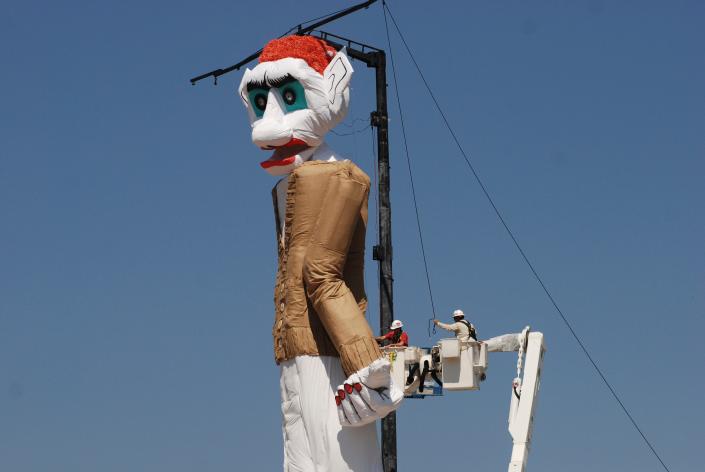 Workers prepare the towering Zozobra marionette for its annual burning at a city park in Santa Fe, N.M.