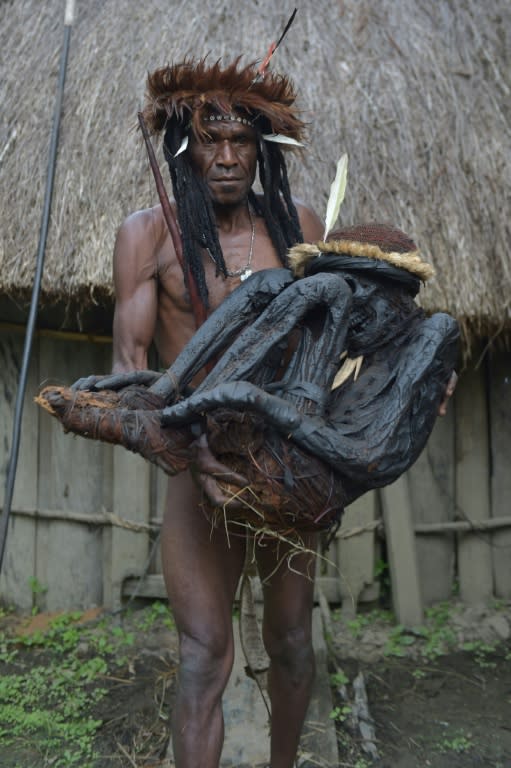 Tribe chief Eli Mabel holds the mummified remains of his ancestor, Agat Mamete Mabel, in the village of Wogi in Wamena, the long-isolated home of the Dani tribe high in the Papuan central highlands on August 7, 2016