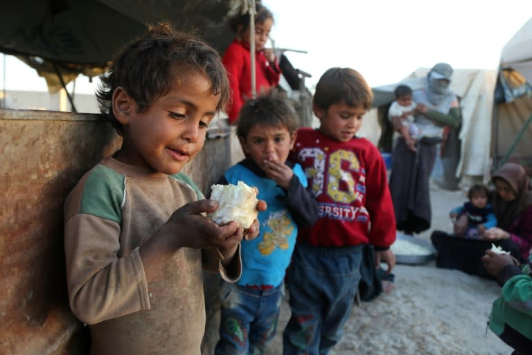 A Syrian child holds a piece of cauliflower at the Ash'ari camp for the displaced in rebel-held eastern Ghouta outside Damascus on October 25, 2017