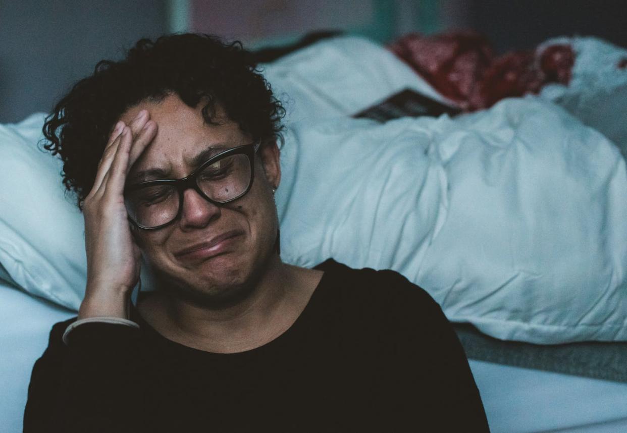 Sometimes emergency housing programs encourage domestic violence survivors to use unsafe alternatives to public programs − even staying with their abusive partner. <a href="https://unsplash.com/photos/person-crying-beside-bed-owBcefxgrIE" rel="nofollow noopener" target="_blank" data-ylk="slk:Claudia Wolff/Unsplash;elm:context_link;itc:0;sec:content-canvas" class="link ">Claudia Wolff/Unsplash</a>