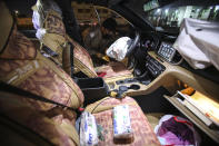 A policeman inspects the car of slain activist Reham Yacoub in Basra, Iraq, Wednesday, Aug. 19, 2020. Activist Reham Yacoub was gunned down in the southern Iraqi province of Basra on Wednesday by unidentified gunmen, a security official and human rights watcher said, marking the second such killing in the span of a week. The official spoke on condition of anonymity in line with regulations. (AP Photo/Nabil al-Jurani)