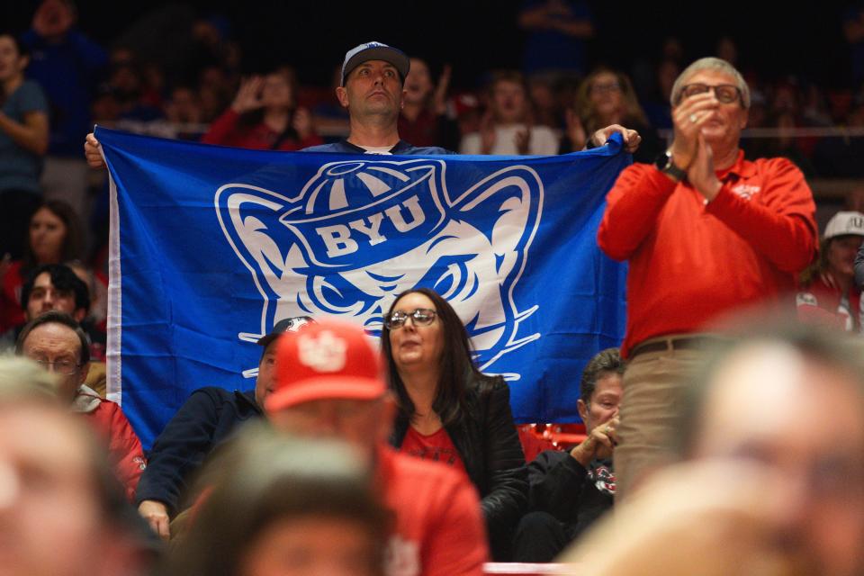 A Brigham Young University fan holds a blue flag in a sea of red before a men’s basketball game against the University of Utah at the Jon M. Huntsman Center in Salt Lake City on Saturday, Dec. 9, 2023. | Megan Nielsen, Deseret News