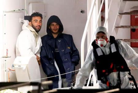 Mohammed Ali Malek (L) and Mahmud Bikhit (C), two survivors of Saturday's migrant boat disaster, arrested on suspicion of people trafficking, are seen as they arrive by Italian coastguard ship Bruno Gregoretti in Catania's harbour late April 20, 2015. REUTERS/Alessandro Bianchi/Files