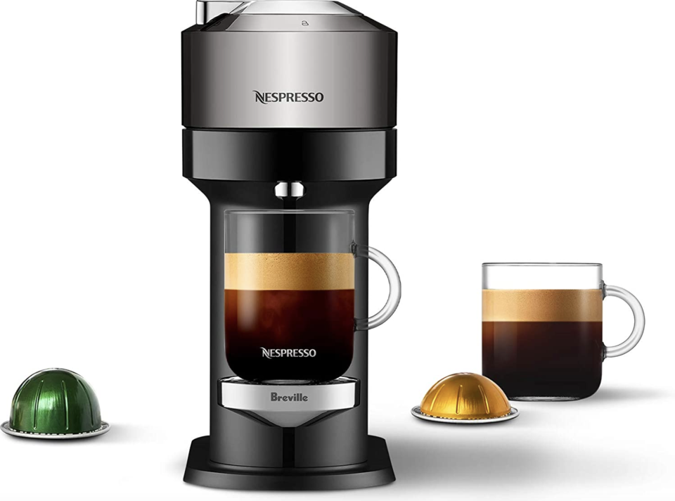 Nespresso Vertuo Next Premium Coffee and Espresso Machine by Breville with two pods and a cup of coffee (Photo via Amazon)