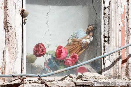 A religious statue slumps to the side after an earthquake hit the island of Ischia, near Naples, Italy August 22, 2017. REUTERS/Ciro De Luca