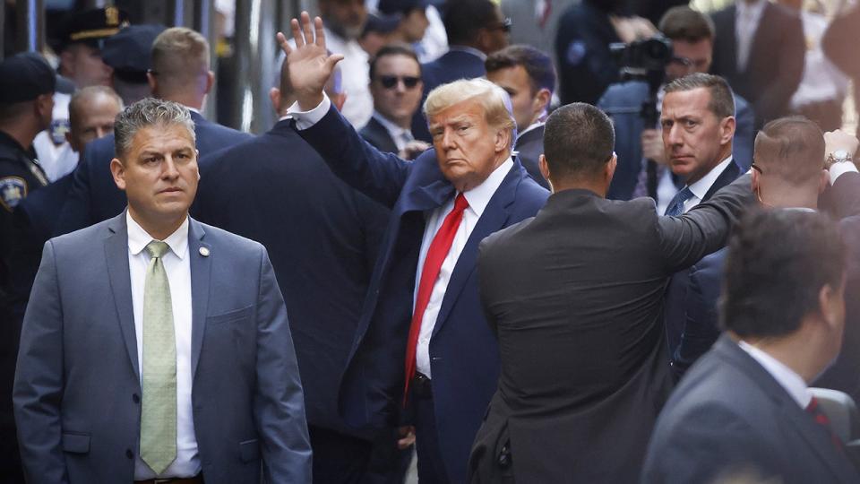 Former U.S. President Donald Trump waves as he arrives at the Manhattan Criminal Court for his arraignment hearing on April 4, 2023, in New York.