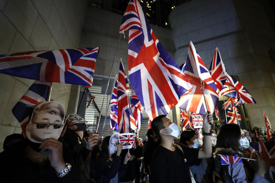 Protesters wave British flags as they gather for a rally outside of the British Consulate in Hong Kong, Friday, Nov. 29, 2019. Hong Kong police ended their blockade of a university campus Friday after surrounding it for 12 days to try to arrest anti-government protesters holed up inside. (AP Photo/Vincent Thian)