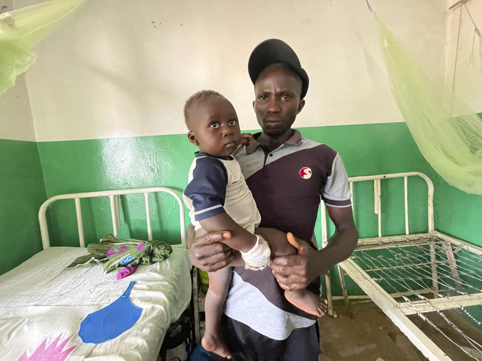 Joshua Jonathan carries his 9-month-old son Christian who is recovering inside a hospital in Kunji, Southern Kaduna, Nigeria, Thursday April 27, 2023. Christian was shot in the leg by unidentified gunmen who also cut his finger after killing his mother. (AP Photo/Chinedu Asadu)