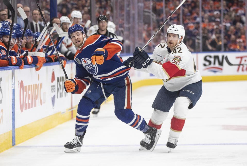 Florida Panthers' Gustav Forsling (42) checks Edmonton Oilers' Dylan Holloway (55) during the second period of Game 6 of the NHL hockey Stanley Cup Final, Friday, June 21, 2024, in Edmonton, Alberta. (Jason Franson/The Canadian Press via AP)