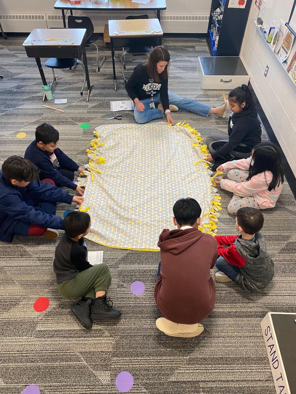 Students at Pine Creek Elementary school work to make a blanket to be donated through the Fleece and Thank You program.
