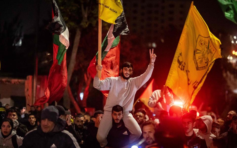 A Palestinian prisoner wearing a grey jumpers gestures among supporters and relatives after being released from an Israeli jail