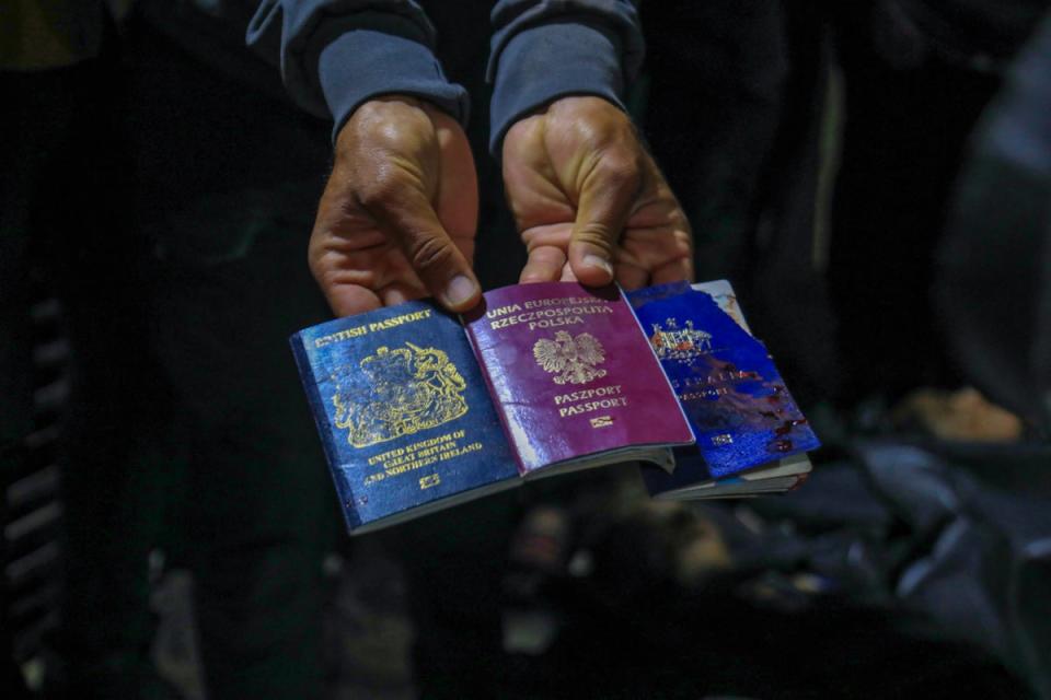 A man displays British, Polish, and Australian passports at Al-Aqsa Hospital in Deir al-Balah, Gaza (AFP via Getty Images)