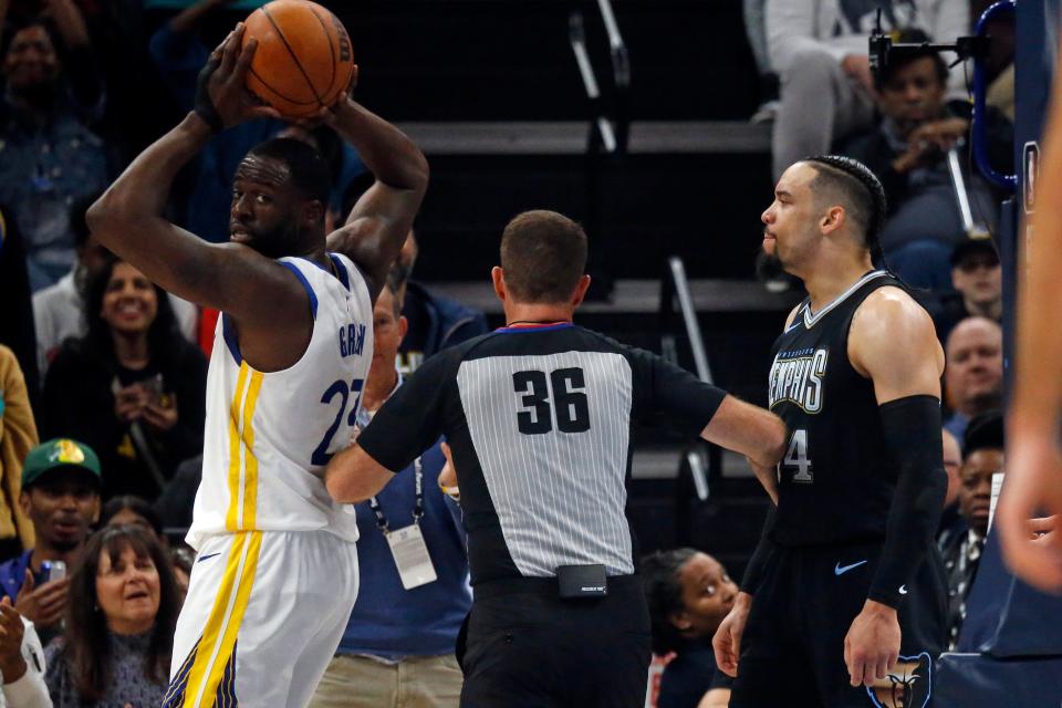 Draymond Green and Dillon Brooks are separated by an official after a basket by Brooks,
