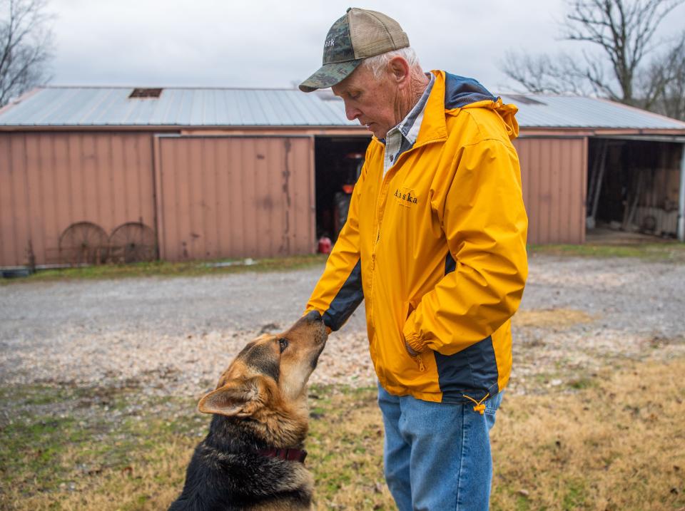 Don Robinson pets his dog as he stands on his property in Hartsville. "We're going to be alright," he said.