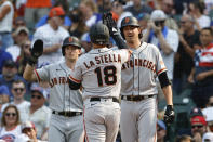 San Francisco Giants' Tommy La Stella, center, celebrates with Mike Yastrzemski, left, and Kevin Gausman, right, as he crosses home plate after hitting a three-run home run against the Chicago Cubs during the fifth inning of a baseball game, Saturday, Sept. 11, 2021, in Chicago. (AP Photo/Kamil Krzaczynski)