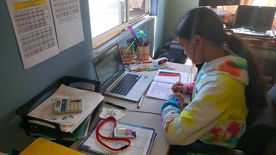 This photo provided by Charles Timtim shows his daughter, name withheld by parents, doing schoolwork from home in Waipahu, Hawaii, Tuesday, Sept. 22, 2020. Timtim's mother doesn't think it's safe for her daughter to be back at school but she also doesn't want her exposed to an online learning program called Acellus that misspelled and mispronounced the last queen to rule the Hawaiian kingdom. Parents spotting questionable content on Acellus is forcing some school districts across the country to reconsider the program or stop using it. (Charles Timtim via AP)