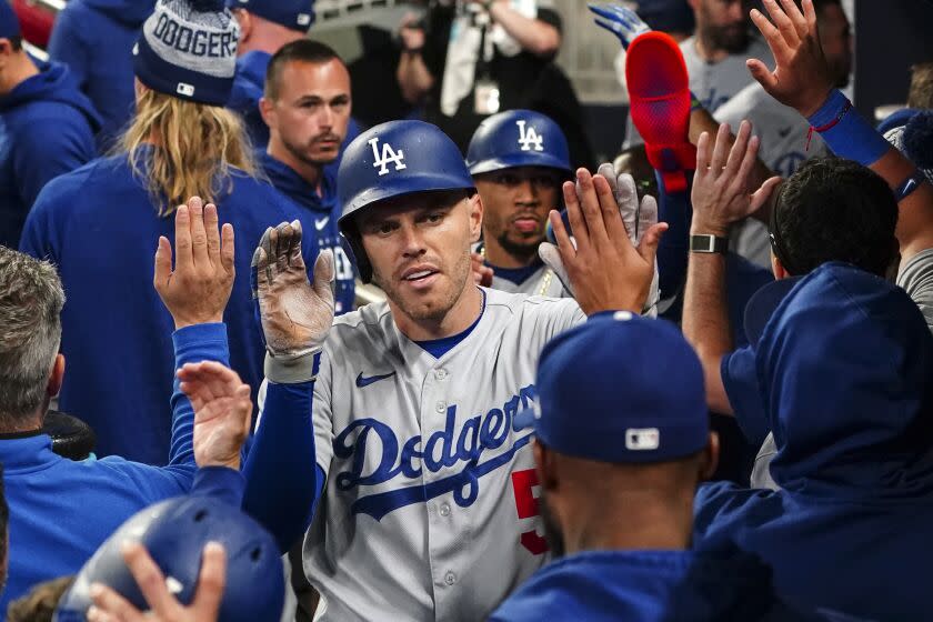 Los Angeles Dodgers' Freddie Freeman (5) celebrates in the dugout after hitting a three-run home run.