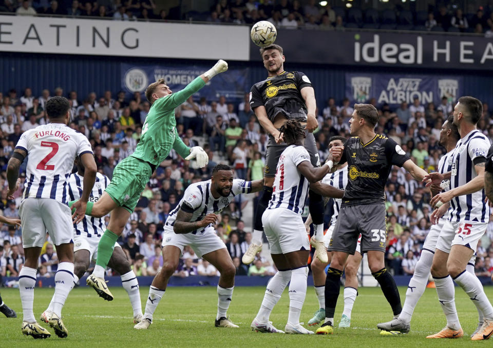 Southampton's Taylor Harwood-Bellis, centre, attempts a header as West Bromwich Albion goalkeeper Alex Palmer tries to punch clear, during the English Football League Championship play-off, semi-final, first leg soccer match between West Bromwich Albion and Southampton, at The Hawthorns, in West Bromwich, England, Sunday May 12, 2024. (Jacob King/PA via AP)