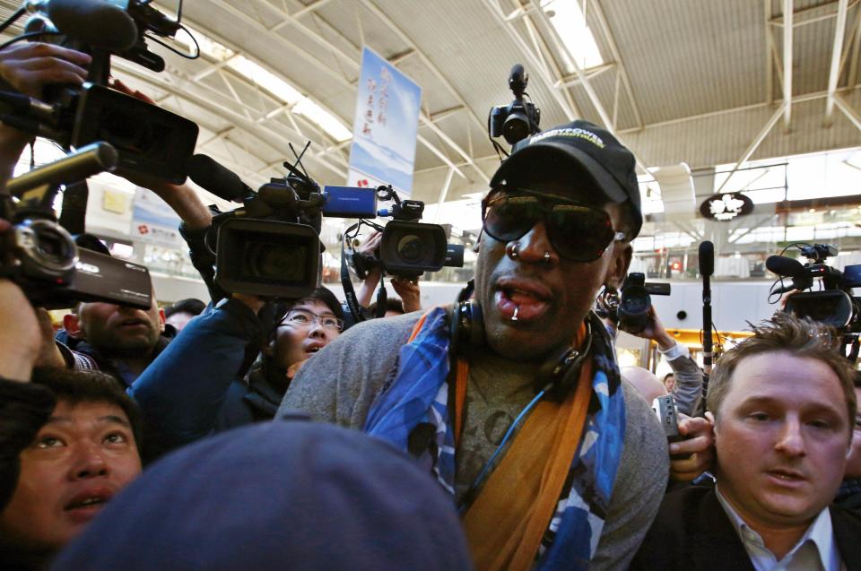 Former NBA basketball player Dennis Rodman is surrounded by media at Beijing International Airport before leaving for Pyongyang