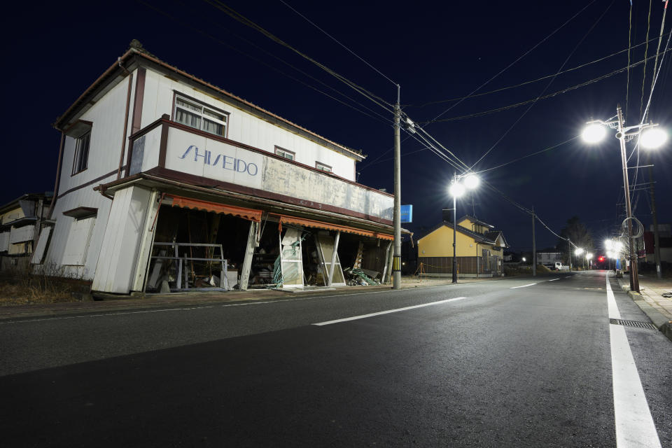 An abandoned shop that would have carried Western-style apparel, accessories and cosmetics looks damaged after the 2011 earthquake, as it stands along a street in Futaba town, northeastern Japan, Wednesday, March 2, 2022. Most damaged buildings have been torn down in the last 11 years. (AP Photo/Hiro Komae)