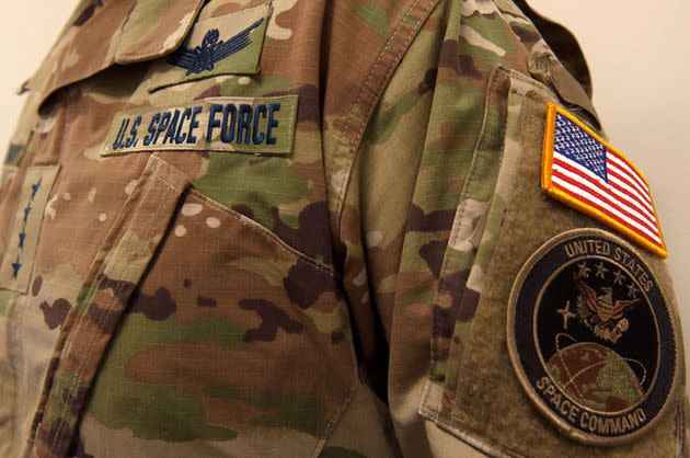 A military camouflage uniform bearing a US Space Force nametape and US Space Command shoulder patch.