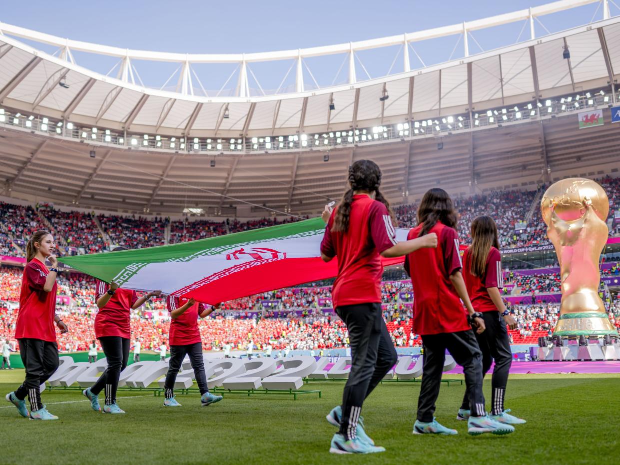 Girls carry the flag of Iran in the stadium during the FIFA World Cup Qatar 2022 Group B match between Wales and Iran at Ahmad Bin Ali Stadium on November 25, 2022 in Doha, Qatar.