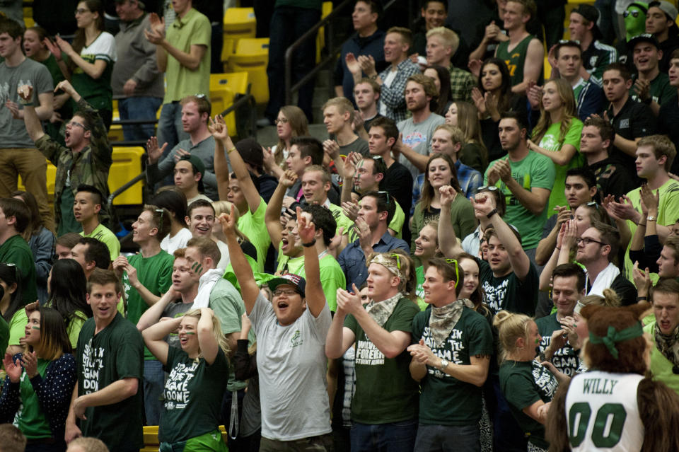 In this Thursday, Feb. 27, 2014 photo, Utah Valley State fans celebrate during the second half of an NCAA college basketball against New Mexico StateNew Mexico State's Daniel Mullings, center left in red and white jersey, is involved in a brawl involving players and fans who came onto the court when New Mexico State guard K.C. Ross-Miller hurled the ball at Utah Valley's Holton Hunsaker seconds after the Wolverines' 66-61 overtime victory against the Aggies in Orem, Utah. (AP Photo/The Daily Herald, Grant Hindsley) MANDATORY CREDIT